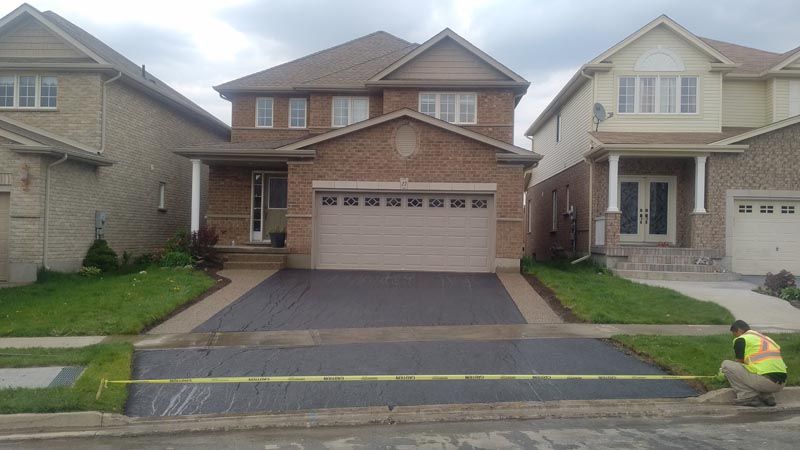 Freshly sealed residential driveway with caution tape